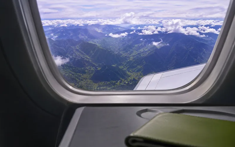 View from an airplane window over green Colombian mountains