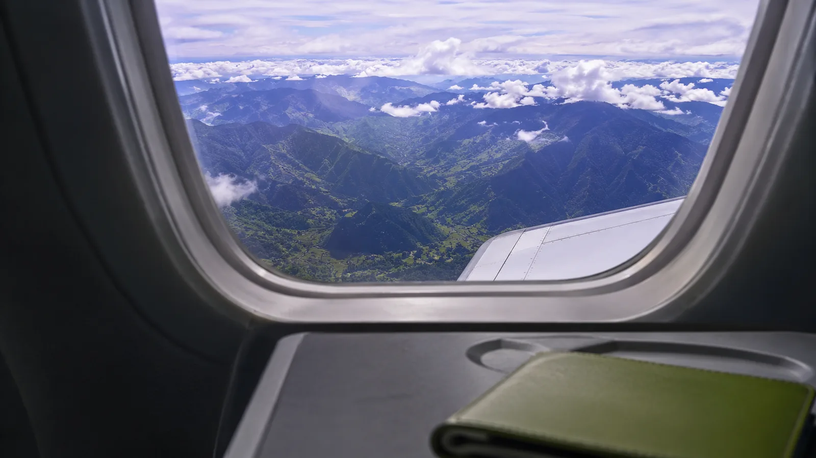 View from an airplane window over green Colombian mountains